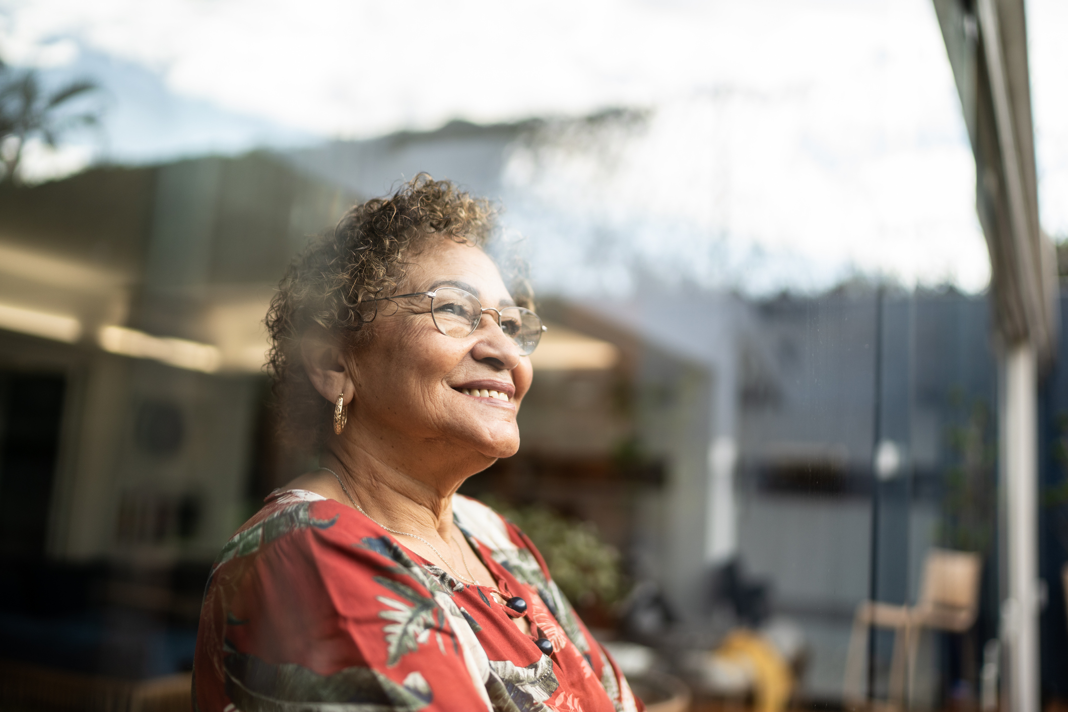 elderly woman looking out her window as she has overcome senior mental health issues