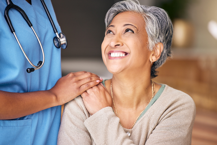 Older woman holding the had of her geriatric doctos